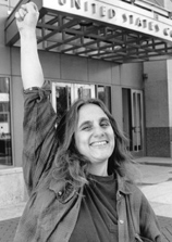 Judi Bari gives the raised fist salute in front of the Oakland Federal Courthouse.